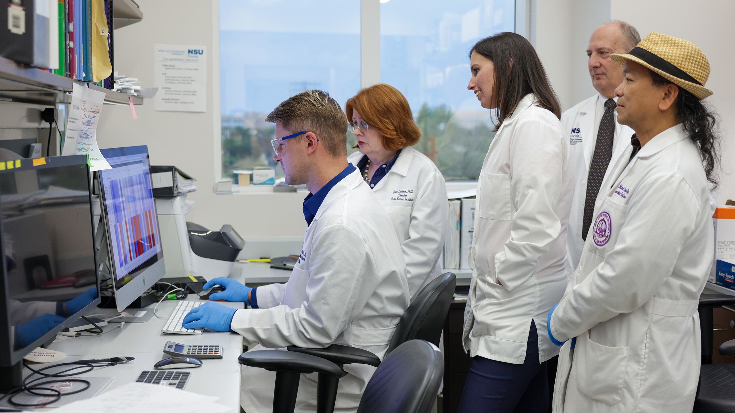 researchers in lab looking at computer monitor