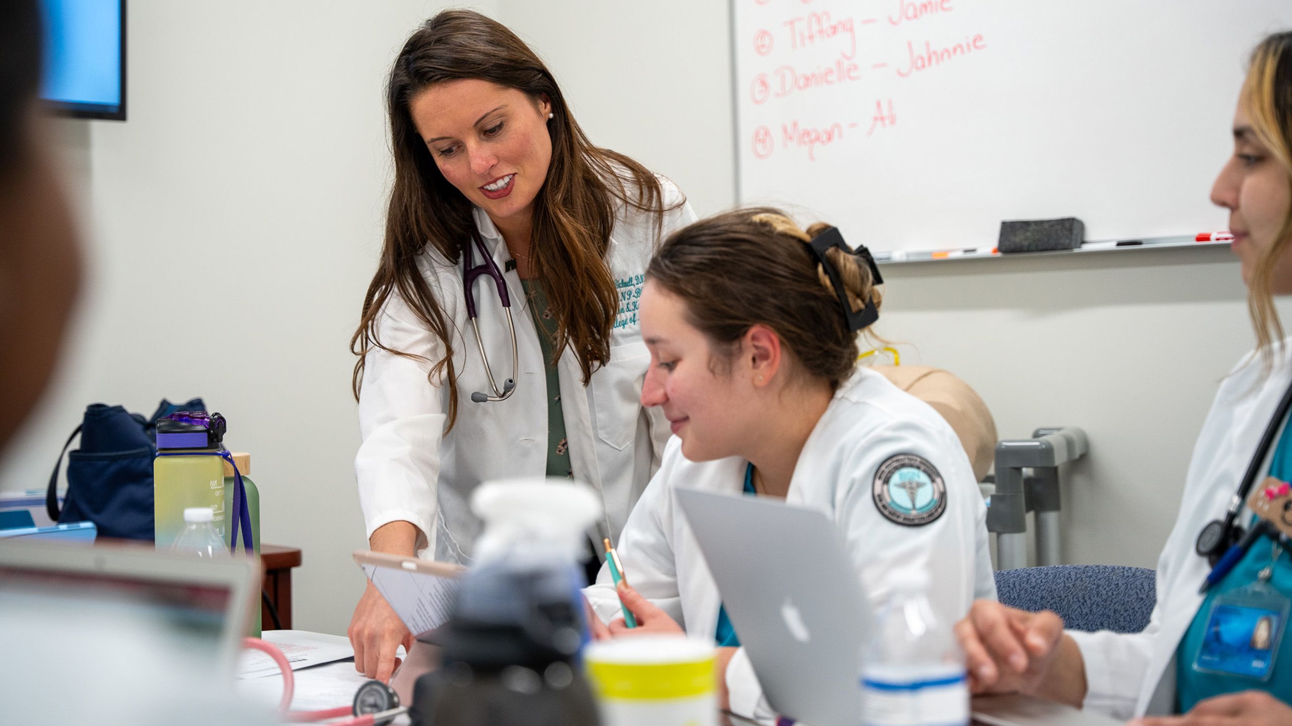 professor talking to a student in a classroom